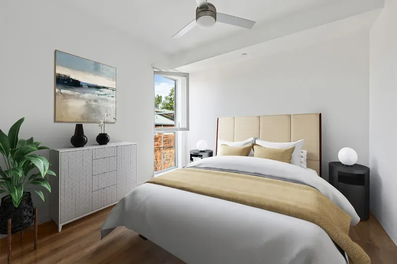 Bedroom with a Large Closet, High Ceiling with Ceiling Fan, Wood-Like Flooring, Bed with Nightstands and Lamps, and a Large Window